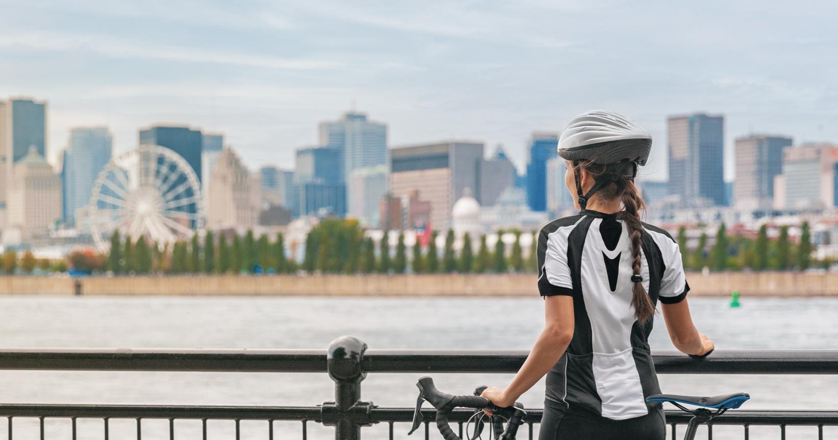 Une cycliste fait une pause en regardant la skyline de Montréal