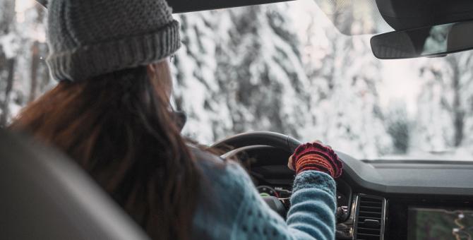 Une femme conduit une voiture en hiver