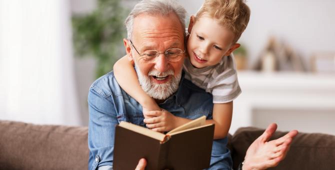 Une personne âgée lit un livre avec un enfant