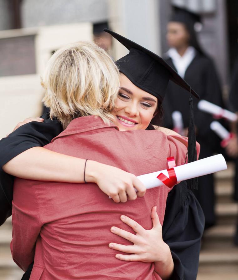 Une diplômée serre quelqu'un dans ses bras