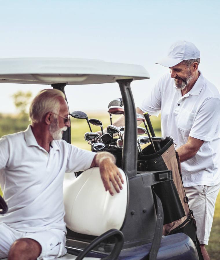 Deux hommes âgés sont assis dans une voiturette de golf